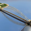 Modern White Arch Bridge With Metal Frame Spanning Water And Blue Sky Reflection