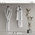 Two White Bathrobes Hanging On Wall In Modern Interior With Green Plant