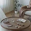 Round Wooden Coffee Table With Clear Glasses Plant Vase Open Book And Teacups
