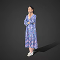 A Woman Standing in Blue Purple Printed Dress with Crossed Arms and White Shoes