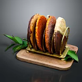 Assorted Colored Bread Slices Displayed on Wooden Tray With Green Leaf Accents