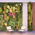 Lush Green Plant Wall with Large Leaves Pink Flowers and White Chairs in Indoor Space