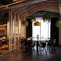 Modern Restaurant Interior With Wooden Partitions Pendant Lights Hanging Plants Round Dining Table And Chairs