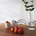 Modern wooden dining table set with metal frame chairs and green plant vase fruits