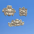 Intricate Silver Carved Ornaments with Floral Patterns Three Decorative Motifs Against Blue Background