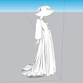 Woman In Long White Dress And Wide Brimmed White Hat Standing In Minimalist Setting