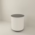 White Cylindrical Kitchen Island With Dark Top And Vertical Stripes In Light Room Corner