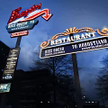 Illuminated Ferrari And Restaurant Signs With Dick Orso 70 In Night View
