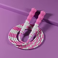 Colorful Pink And White Jump Rope With Pink Handles On Purple Surface