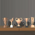 Various Trophies With Different Designs On Wooden Table Against Dark Vertical Striped Wall