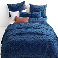 Double Bed with Blue Diamond Pattern Quilt and Soft Decorative Pillows
