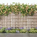 Vines With Yellow Flowers Growing On Wooden Fence Surrounded By Purple Flowers And Green Plants