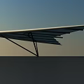 Modern Sleek Wing Like Structure With Black Support Against Sky And Ground 3d model