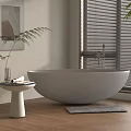 Round Gray Bathtub in Modern Bathroom Interior with Pedestal Table Fern Plant and Wooden Floor