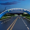 Blue Arch Entrance Gate in Qinzhou Port Free Trade Zone with Road Vehicles and Evening