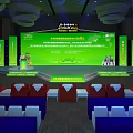 Large Conference Venue With Green Stage Speaker Red White Chairs And Big Screen