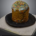 Traditional Sweet Bread With White Frosting And Colorful Sprinkles On Black Plate And White Mat