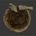 Two Bird Sculptures Perched On Woven Bird Nest Against Dark Background