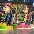 Vibrant Flower Shaped Art Installations With Colorful Block Planters In Mall Atrium