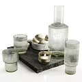 Transparent Ribbed Glasses with Macarons Lit Candle and Glass Bottle on Slate Tray