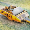 Utility Vehicle Yellow Rusty Drum Component Lying On Green Grass Field