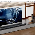 Modern Flat Screen Television On Stand With Waterfall Display And Decorative Items