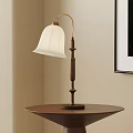 Classic Table Lamp With White Lampshade And Curved Wooden Base On Brown Round Table