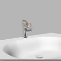 Silver Modern Bathroom Faucet On White Sink With Green Leaf Accent