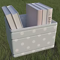Light Gray Polka Dot Storage Bin With Books On Green Grass Background 3d model