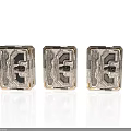Three Transparent Metallic Cube Components With Intricate Geometric Patterns And Shiny Surfaces