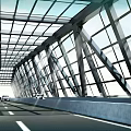 Modern Bridge Spanning River With Green Landscaping And Highway Connections