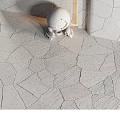 Gray Irregular Shaped Textured Floor Tiles With White Small Robot And Light Colored Walls