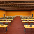 Classroom With Yellow Walls Wooden Floors And Rows Of Desks With Laptops And Water Cups