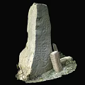 Ancient Stone Stela Surrounded By Small Stones And Grass In Historical Site