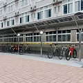 Metal Frame Bicycle Scooter Canopy Near Multi Storey Building with Brick Paved Ground