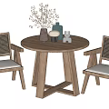 Wooden Round Table And Rattan Back Gray Cushioned Chairs With Decorative Vases