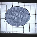 Round Gray Manhole Cover On Square Tiled Urban Pavement Surface 3d model