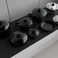 Modern Kitchen Cookware Collection With Black Pots Pans And Lids On Countertop
