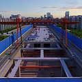 Road Infrastructure Construction at Urban Site With Red Crane Structure and Blue Barriers