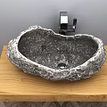 Natural Stone Rock Washbasin On Wooden Countertop With Black Faucet And Gray Wall
