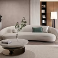 Modern Beige Curved Sofa And Round Coffee Table Set With Green Cushions Plant And Books