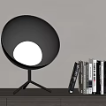 Silver Spherical Table Lamp With Tripod Base And Stacked Books On Desk