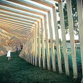 Wooden Pergola Linear Striped Design In Outdoor Garden With Green Grass Trees And People Walking