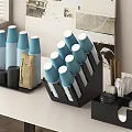 Organized Stacked Coffee Cups with Blue Lids in Black Holder on White Table