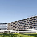 Modern Office Building Exterior Design With Multiple Balconies Glass Railings And Greenery