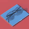 Modern Rectangular Glasses Neatly Placed On Blue Lined Notebook Against Red Background