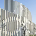 Contemporary Museum Building Featuring Circular Design And White Geometric Facade In Green Surroundings