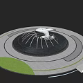 Circular Water Fountain With White Sculpture Surrounding Green Lawn And Gray Pavement