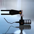 Black Mechanical Clamp Device With Cylindrical Base And Cable On Smooth Surface