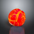 Vibrant Red And Yellow Fruit Ball With Cracked Surface On Black Background